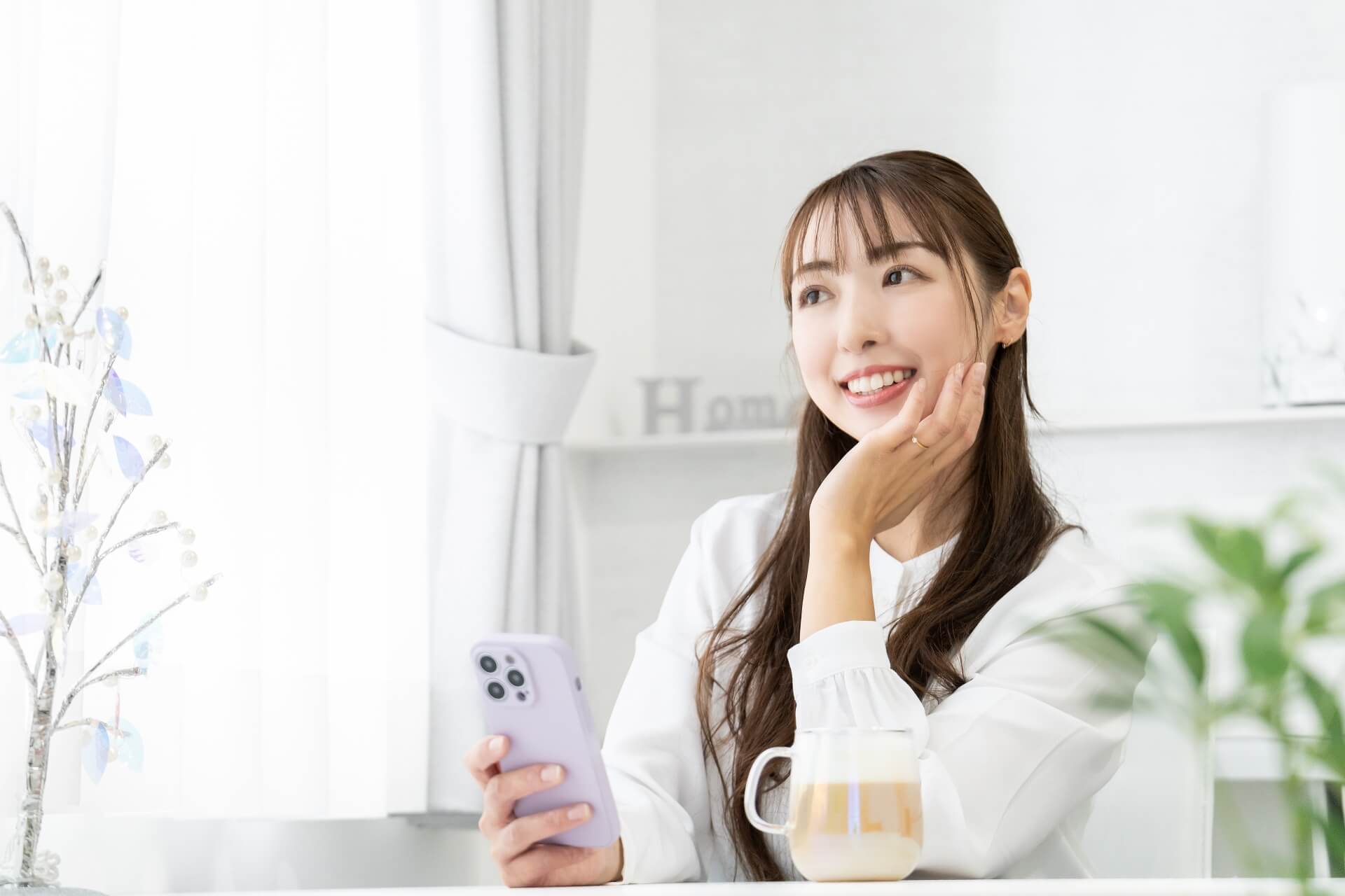 リビングでスマホを使う笑顔の女性