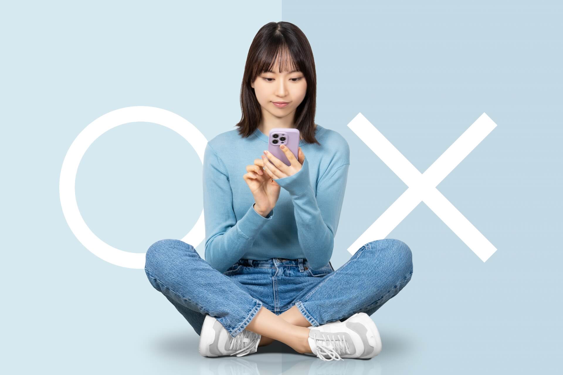 マルかバツか、スマホを見ながら考える女性