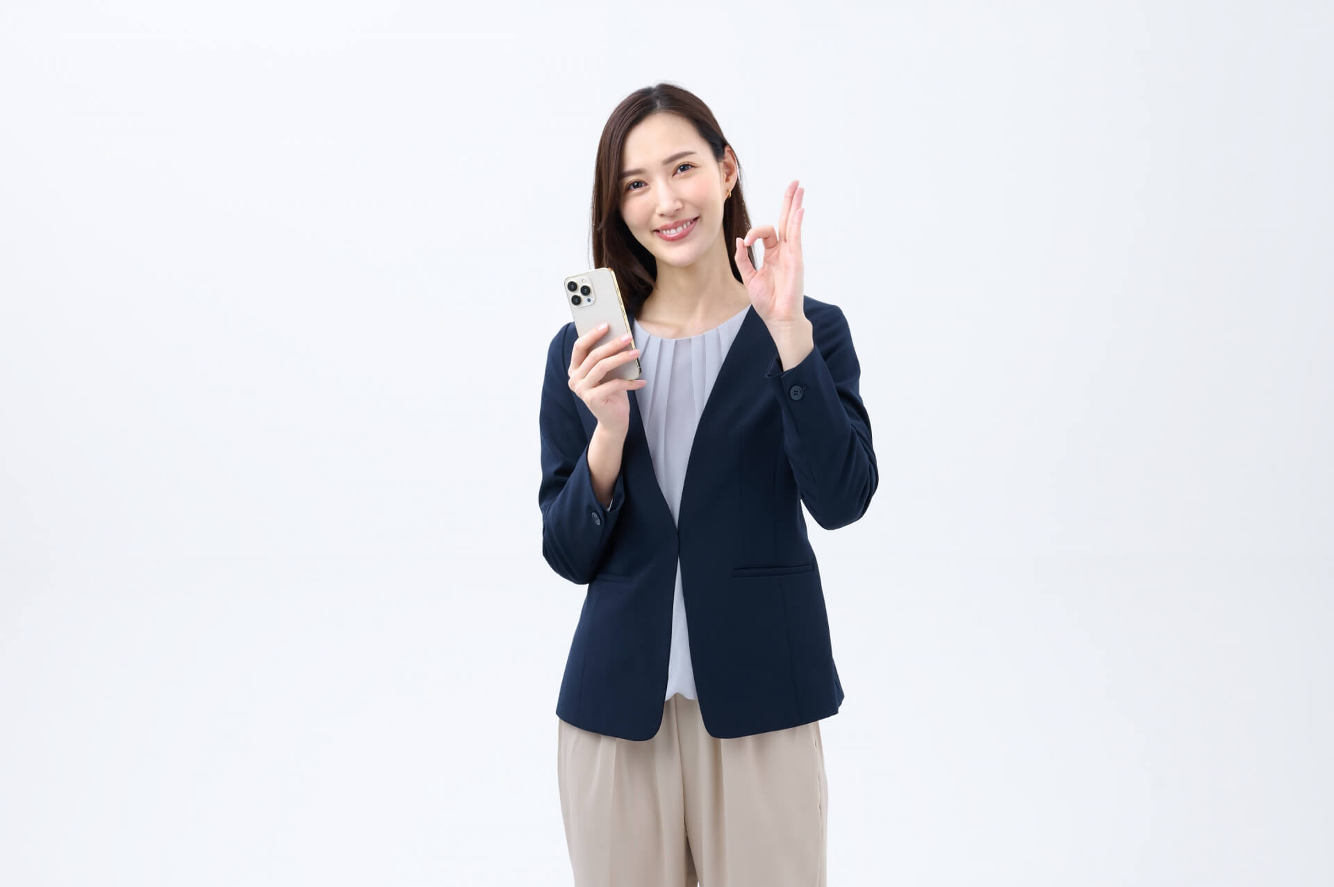 OKサインするスマホを持つ女性